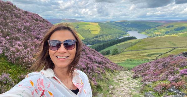 A woman on top of a hill smiling to camera